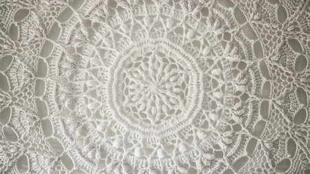 Close up view of a handmade white crochet doily, highlighting the intricate craftsmanship and delicate patternsの写真素材