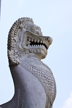 antique guardian lion sculpture in front of the temple, thailand の写真素材