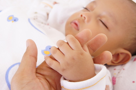 A baby holding his father's fingerの写真素材
