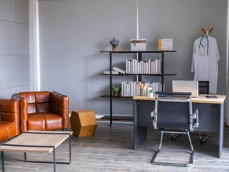 Doctor workplace in office. Modern interior of doctor's office of gynecologist in a clinic. Clean and light interior of medical office.の写真素材