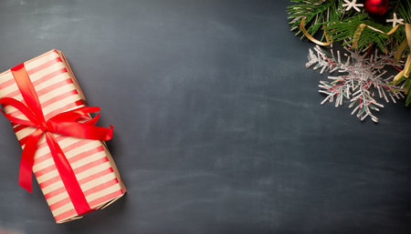 Christmas gift box on blackboard background. Top view with copy spaceの素材