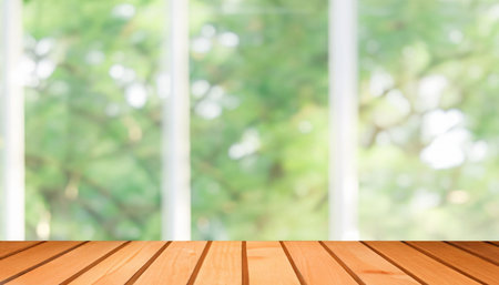 Wood table top on blur window with bokeh background - can be used for display or montage your productsの素材