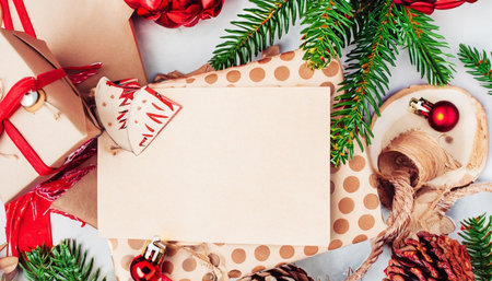 Christmas greeting card mockup with gift boxes, fir tree branches and decorations. Top view with copy spaceの素材