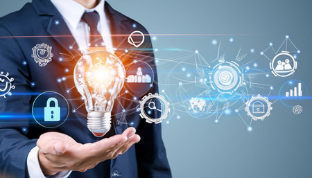 Businessman on blurred background holding a glowing lightbulb in his hand 3D renderingの素材