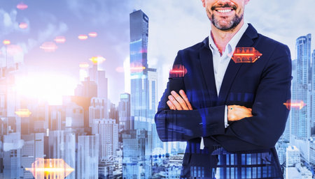 Cropped image of smiling businessman with crossed arms standing against cityscape backgroundの素材
