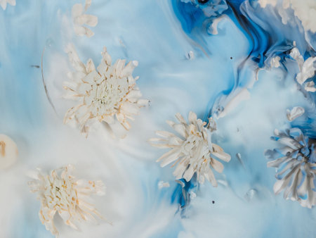 abstract background of blue and white acrylic paint in water with white flowersの素材