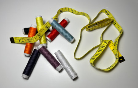 spools of thread and measuring tape on a white background, sewing conceptの写真素材