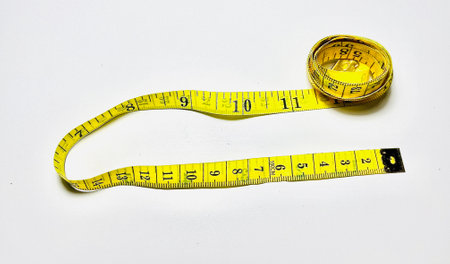 Measuring tape on a white background. The measuring tape is yellow.の写真素材