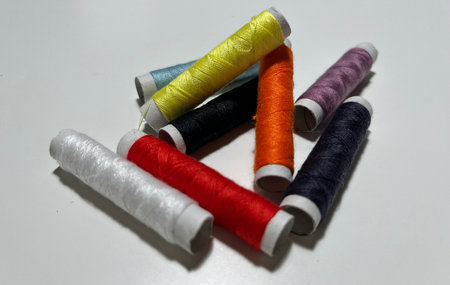 Spools of multicolored thread on a white background close up