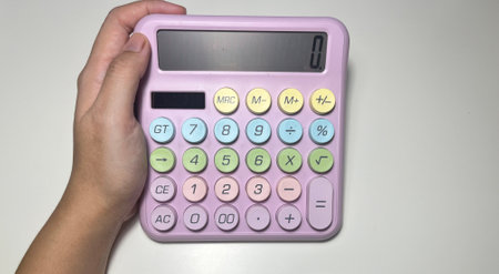 Calculator in hand on white background. Close-up.の写真素材