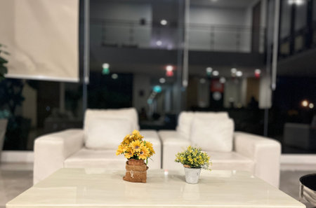 Interior of a modern living room with a white sofa and a table with flowersの写真素材