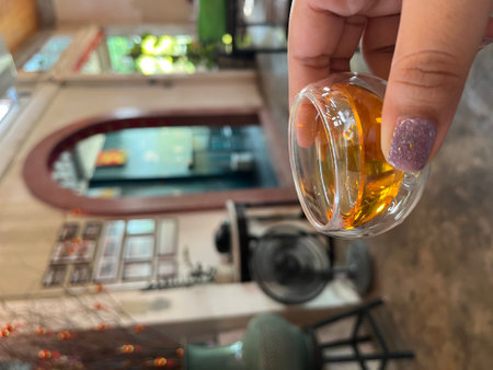 Woman's hand holding a bottle in a restaurant.の写真素材