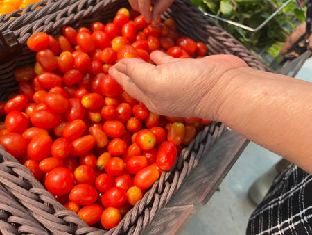 Fresh cherry tomatoes in a basket on a market. Selective focus.の写真素材