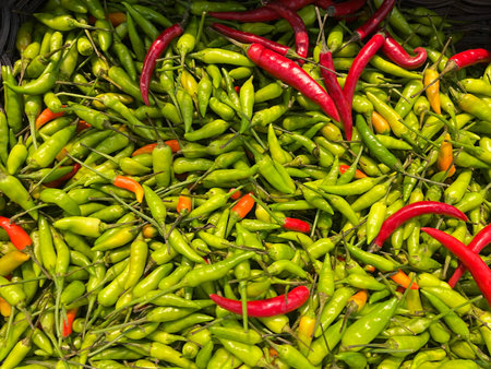 Red and green hot chili peppers on the counter in the market.
