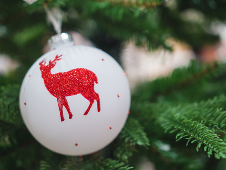 close up reindeer ball white hanging on christmas treeの写真素材