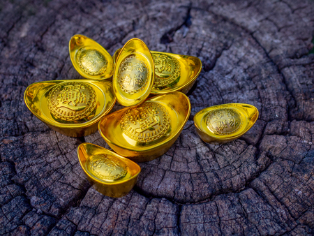 Lunar Chinese new year decoration traditional on wooden background, the chinese character on the gold ingots meaning wealth, wealth and stability.の写真素材