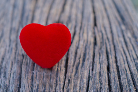 The red heart is placed on the wooden floor and have copy space for design in your work. The red heart represents the day of love.の写真素材