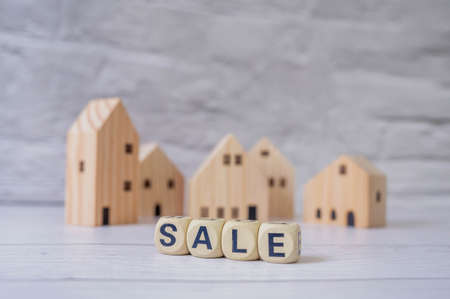 Miniature house and wooden blocks with the word sale on marble table.Real estate concept.Rent apartment. Property. Rental, renting home. Buying. Purchase housingの写真素材