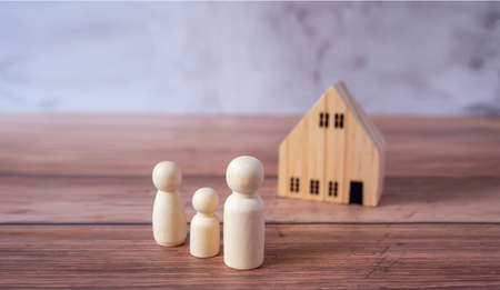 Mini wood house model and wooden figure of people in family include parents and children on wood table,Planning buy Real Estate and property and Choose the best.Work from home and stay home concept.の写真素材