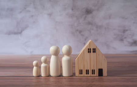 Mini wood house model and wooden figure of people in family include parents and children on wood table,Planning buy Real Estate and property and Choose the best.Work from home and stay home concept.の写真素材