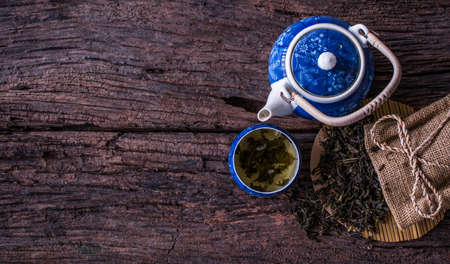 Hot green tea in a cup on wooden background. It is a natural herb drink green tea for good health. Presents in a flat lay, top view, copy space.の写真素材