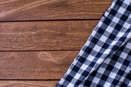 Tablecloth textile checkered pattern cotton on wooden background. Top view with copy space.