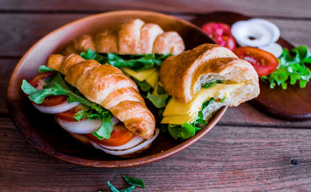 Freshly croissant sandwich on wooden background. It is a type of French pastry suitable as breakfast. No one doesn't know the croissant and can be purchased at bakery worldwide.の写真素材