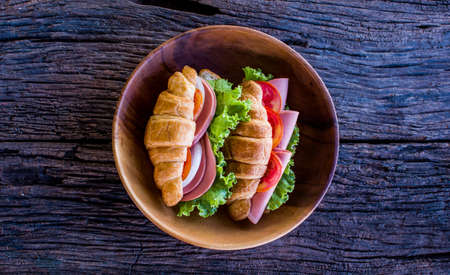 Freshly croissant sandwich on wooden background. It is a type of French pastry suitable as breakfast. No one doesn't know the croissant and can be purchased at bakery worldwide.の写真素材