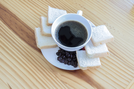 A cup of black coffee beans and bread. Daily foodの写真素材