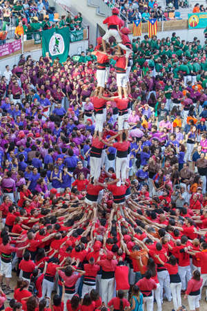 TARRAGONA, SPAIN - OCTOBER 6:  Members of \\\"Colla Joves Xiquets de Valls \\\", build a traditional human tower at the Tarragona during the celebrations in Tarraco Arena Pla?a,  castles contest, October 6, 2012, Tarragona, Spainのeditorial素材
