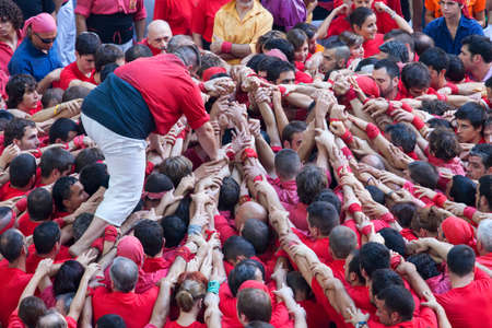 TARRAGONA, SPAIN - OCTOBER 6:  Members of \\\"Colla Joves Xiquets de Valls \\\", build a traditional human tower at the Tarragona during the celebrations in Tarraco Arena Pla?a,  castles contest, October 6, 2012, Tarragona, Spainのeditorial素材