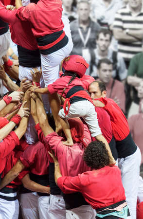 Tarragona, Spain - October 6, 2012: Members of the \\\"Colla Xicotes de Vilafranca\\\", build a traditional human tower at the Tarragona during celebrations in Tarraco Square Sand castle contest, October 6, 2012, Tarragona, Spain.  A perfect example of teのeditorial素材