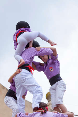 Tarragona, Spain - May 19, 2013: Members of the \\\"Colla Jove Xiquets de Tarragona\\\", build a traditional human tower at the Tarragona during celebrations in \\\"Tarraco Viva\\\", May 19, 2013, Tarragona, Spain.  A perfect example of teamwork, union anのeditorial素材