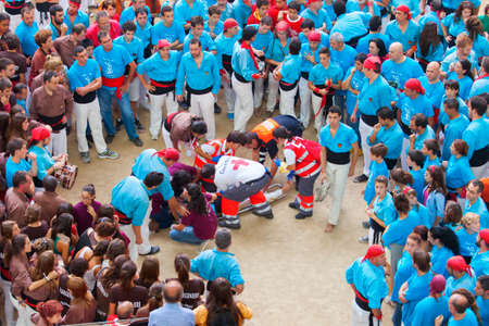 Tarragona, Spain - October 6, 2012: Members of the \"Castellers de Terrassa\", caring for a partner who is hurt in the collapse of a castle during celebrations in Tarraco Square Sand castle contest, October 6, 2012, Tarragona, Spain.  A perfect example ofのeditorial素材