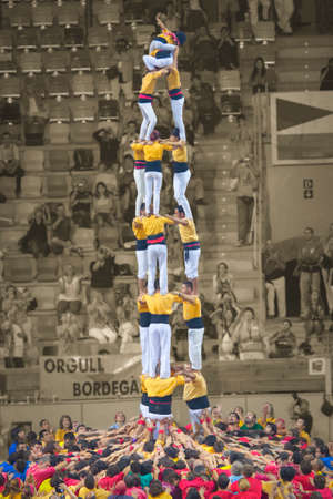 Tarragona, Spain - October 6, 2012: Members of the \"Castellers de Badalona\", build a traditional human tower at the Tarragona during celebrations in Tarraco Square Sand castle contest, October 6, 2012, Tarragona, Spain.  A perfect example of teamwork, uのeditorial素材
