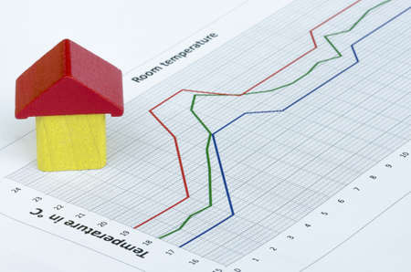 Wooden house build from wooden blocks on temperature graphの写真素材