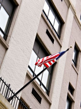 An American flag waving on the side of an office building. の写真素材