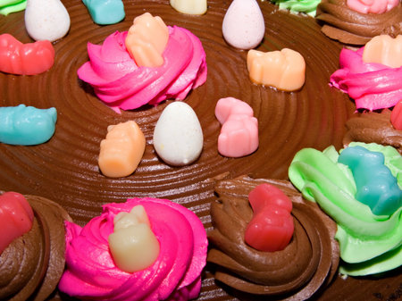 A chocolate frosted cake top with colorful decorations. 