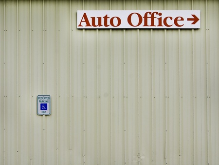 Signs on a building with aging rutsing metal walls.の写真素材