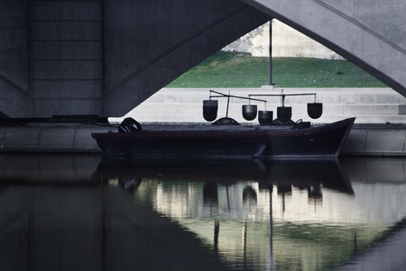 A work type motor boat tied up under a bridge. の写真素材