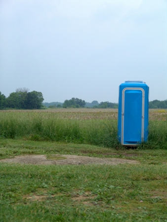 A modern outhouse in a farm field with nothing else around.                                の写真素材