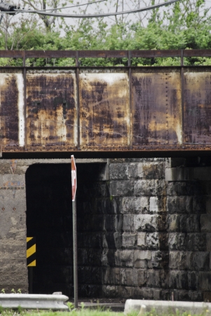 An old railroad overpass with aged block walls below. の写真素材