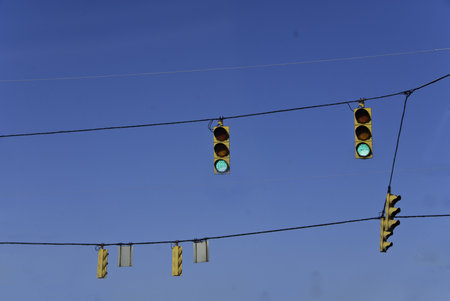 Traffice lights in the sky with cables and lines holding them up. 