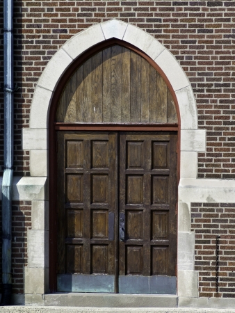 Chursh doors set in a red brick sturcture with a drain pipe on the side. の写真素材