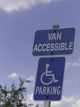 A set of handicap signs agains at blue sky with white clouds. の写真素材