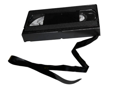 A VCR tape cassette with a broken string of film tape. の写真素材