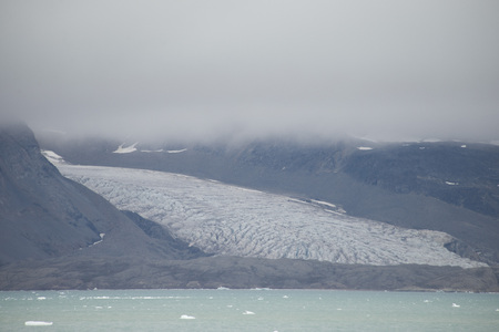 Beautiful view of the clouds over snowy mountains and ice floes in the Arcticの写真素材