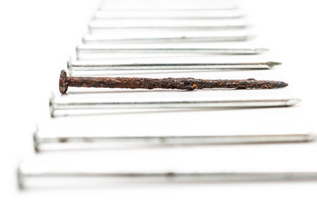 Old rusty nail between new ones. Weak point metaphorの写真素材