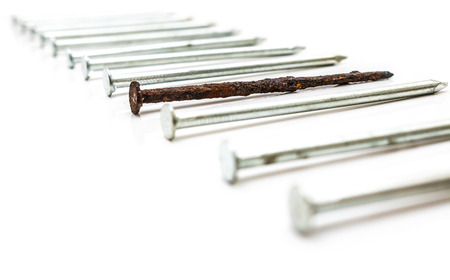Old rusty nail between new ones. Weak point metaphorの写真素材