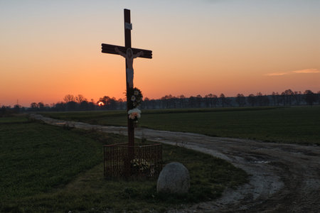 Cross in the field at sunset. The cross is a symbol of Jesus Christ.の写真素材